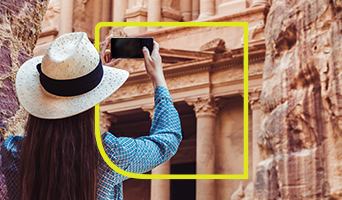 a girl taking a picture of Petra in Jordan